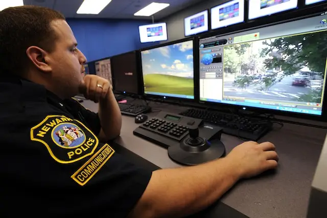 Communications clerk Angel Castro monitors a remote surveillance camera view in Newark PD's Surveillance Operations Center in 2008
